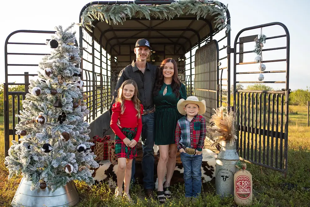 Justin Hearl with his wife, daughter and son in front of a stock trailer at Christmas