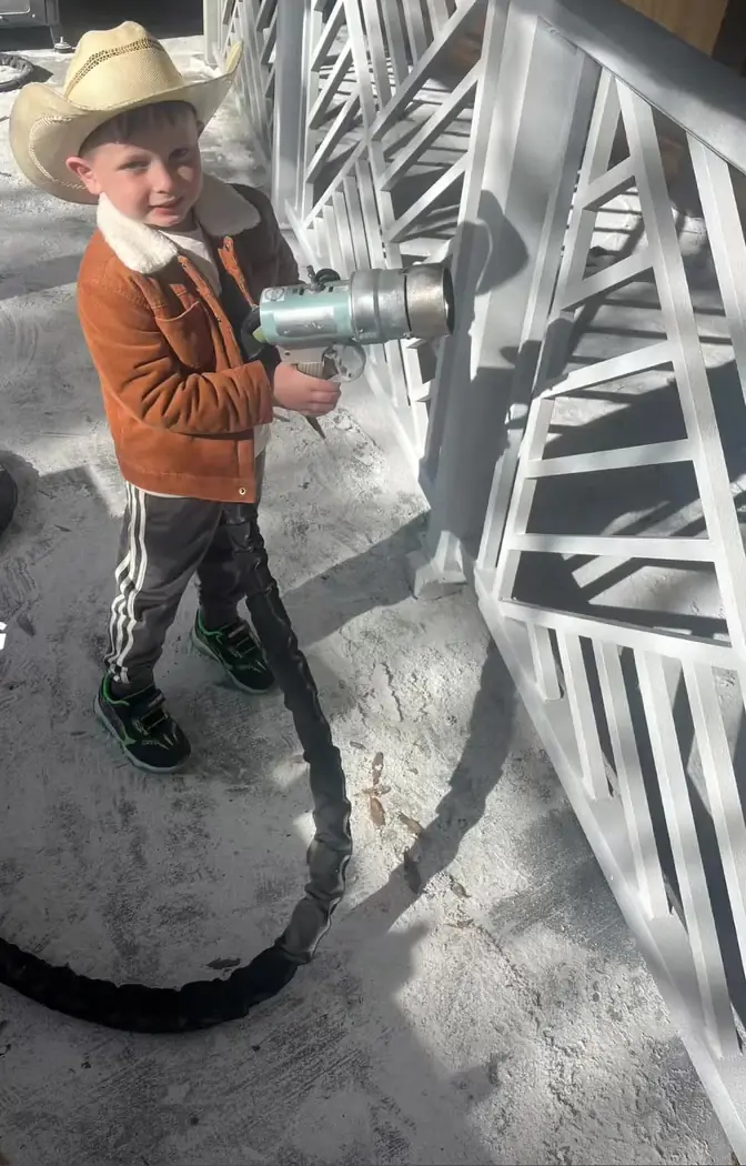Justin's son holding the blast nozzle next to gate panels, Treasure Coast Mobile Sandblasting