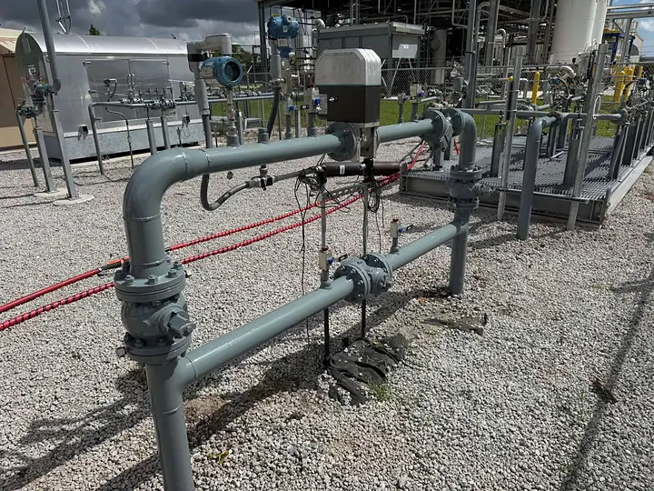 Above-ground gas line piping blasted and coated gray at a Florida meter station