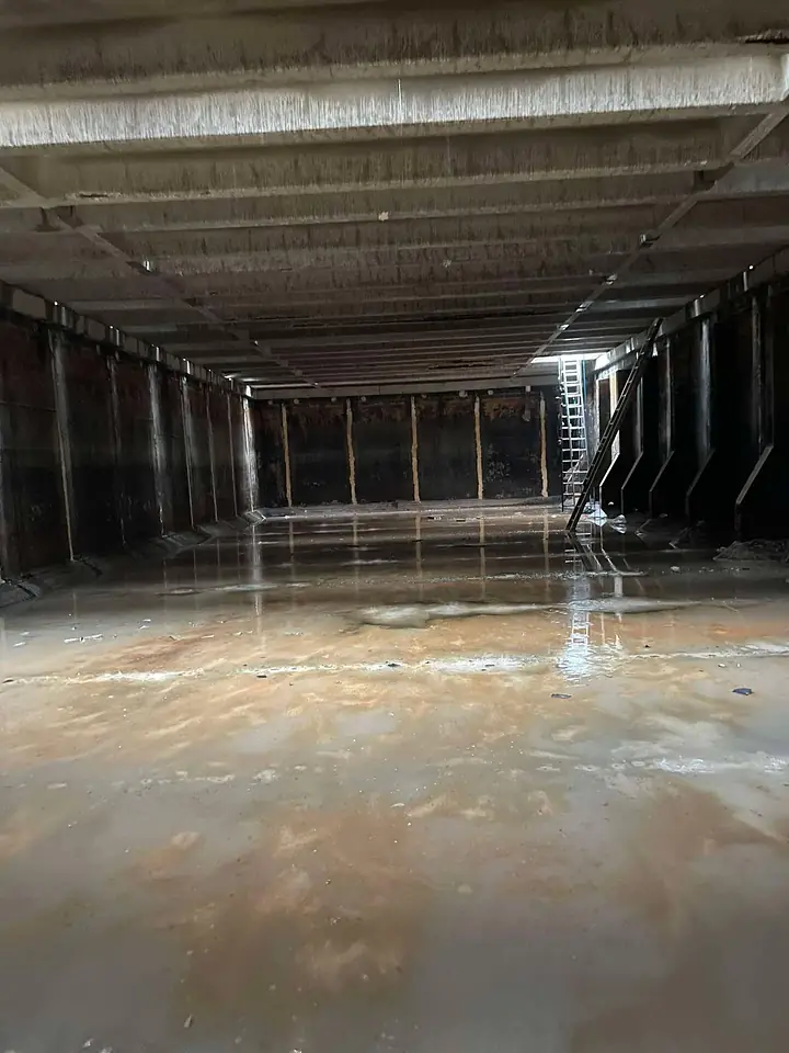 Inside a large industrial tank before blasting and recoating