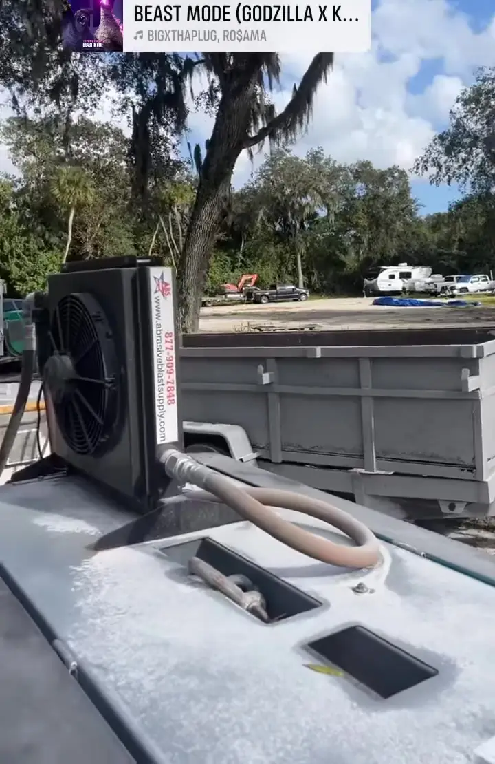 Mobile sandblasting rig with blast pot and aftercooler set up on a job site near Vero Beach, FL